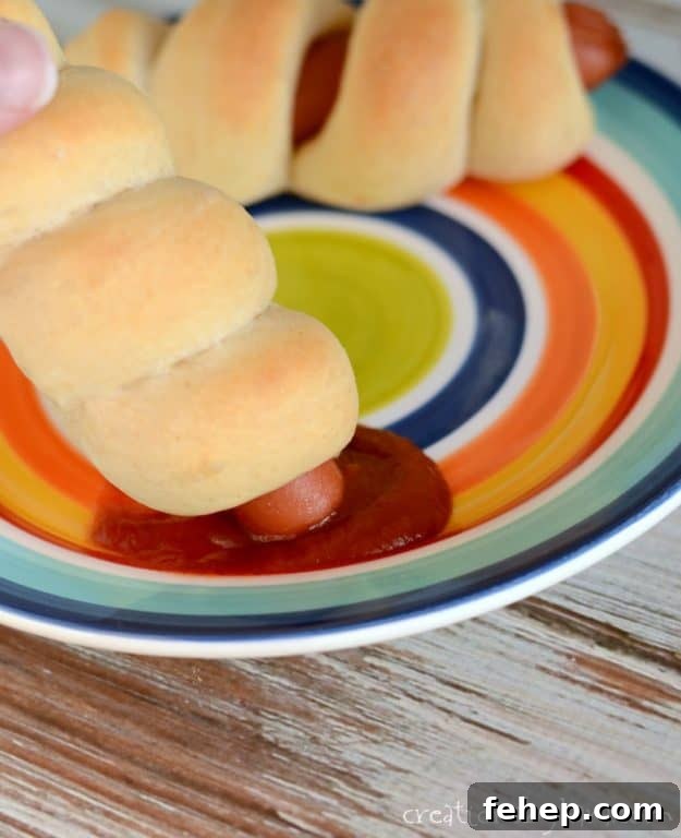 Soft and flavorful pigs in a blanket. A favorite dinner recipe of kids everywhere! pig in blanket dipped in ketchup