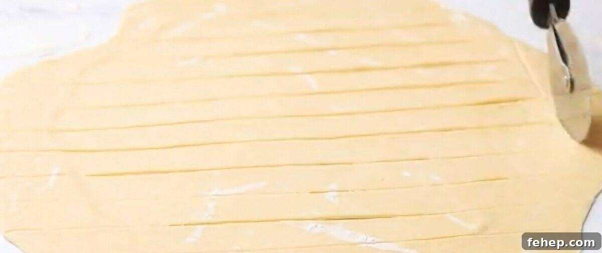 Classic Chicken and Dumplings Recipe for Comforting Weeknight Dinner 6 Cutting the dumpling dough with a pizza cutter.