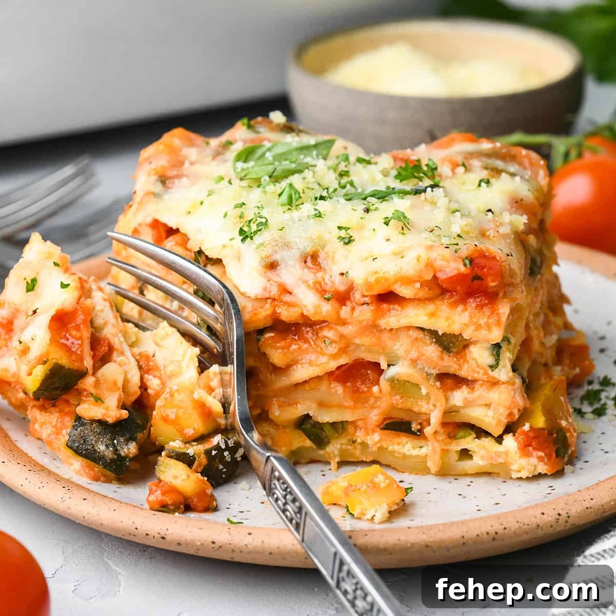 Hearty Vegetable Lasagna Recipe with Spinach & Ricotta 15 a fork taking a bite of vegetarian lasagna on a plate