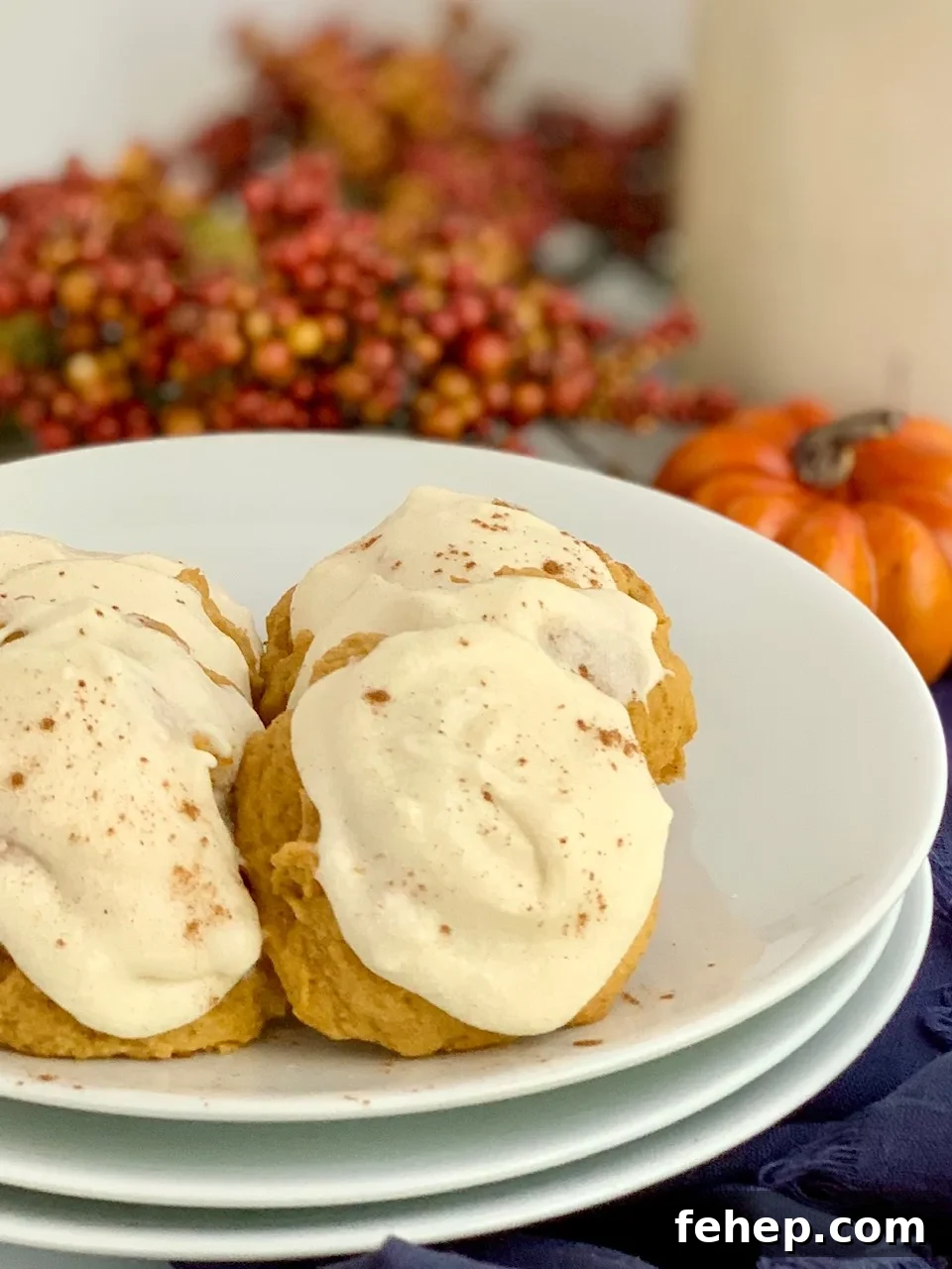 Pumpkin cookies with cream cheese frosting on a plate with a glass of milk