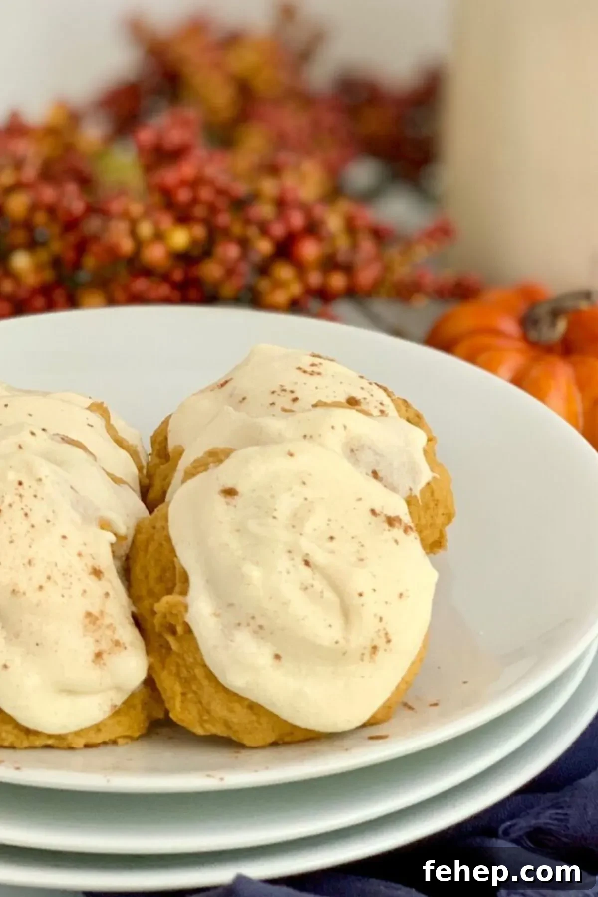 A plate with a few cream cheese frosted pumpkin cookies.