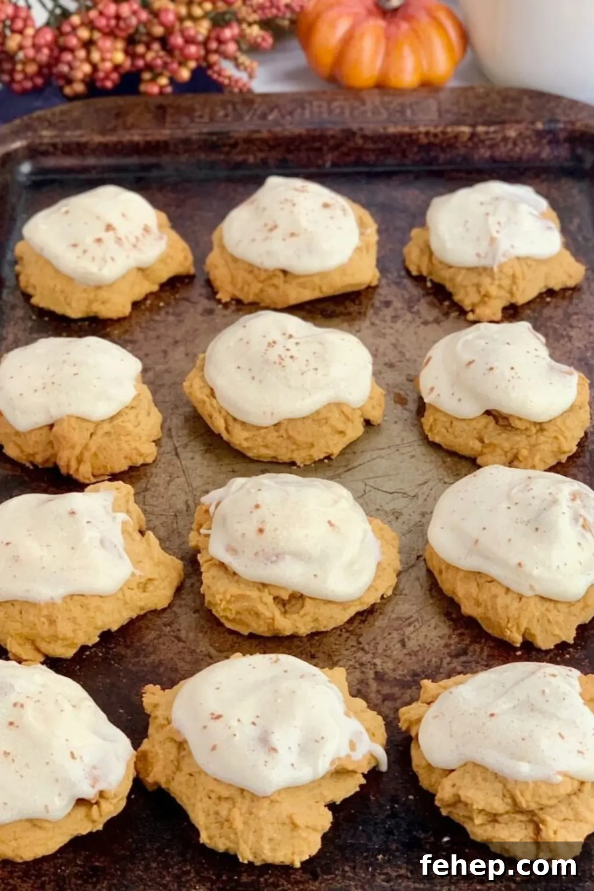 A baking sheet with frosted gluten-free pumpkin cookies