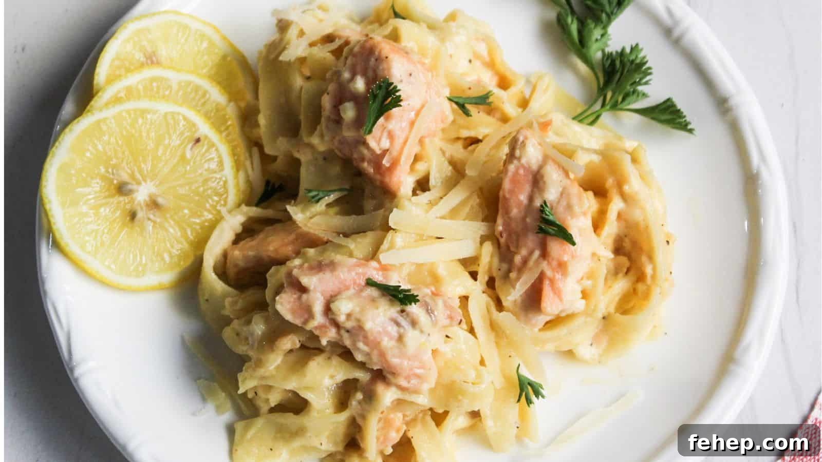 19 Authentic Italian Dinners That Feel Effortless and Homey 16 Salmon pasta Alfredo served on a white plate with lemon.