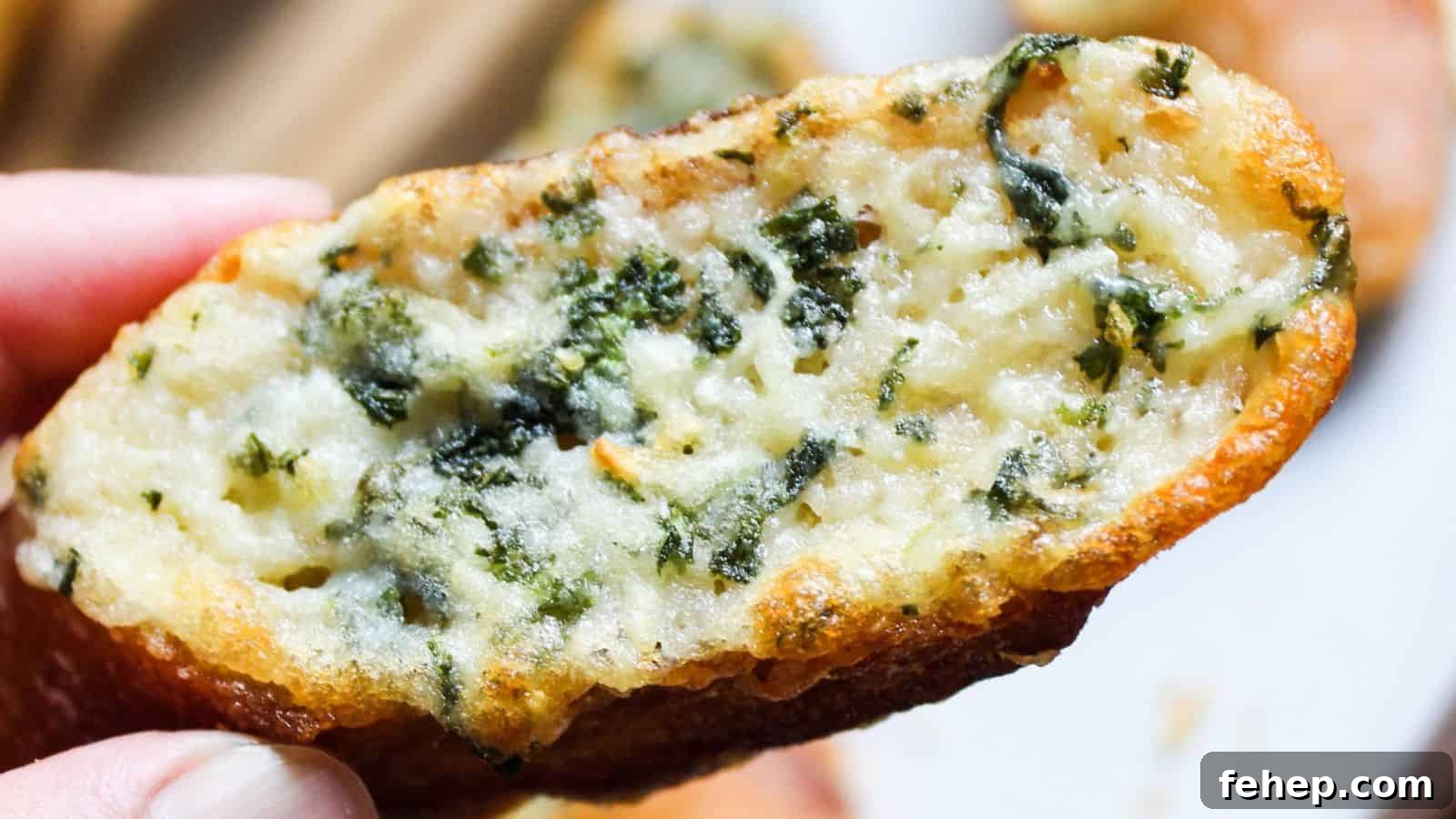 19 Authentic Italian Dinners That Feel Effortless and Homey 5 Close-up of a garlic bread slice topped with melted cheese and herbs held over a plate.