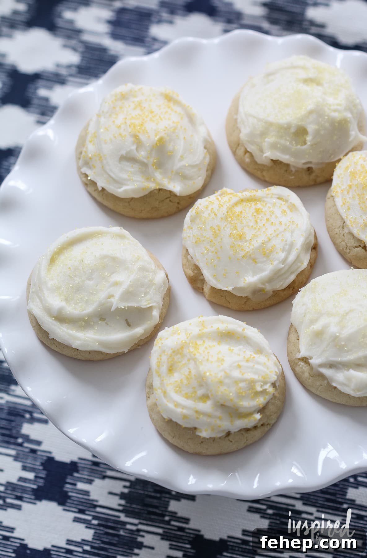 seven Soft Frosted Lemon Cookies on a cake stand.