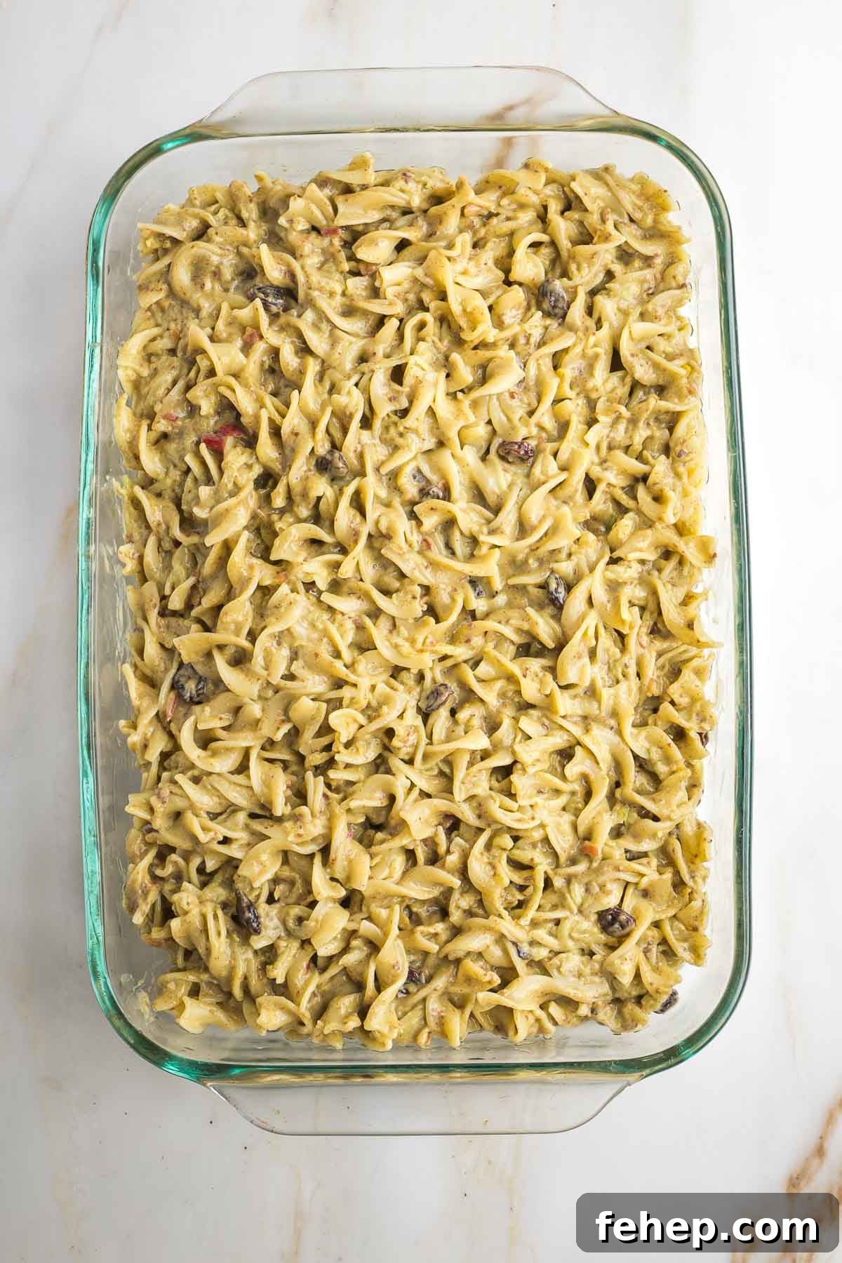 Unbaked noodle kugel in a baking dish.