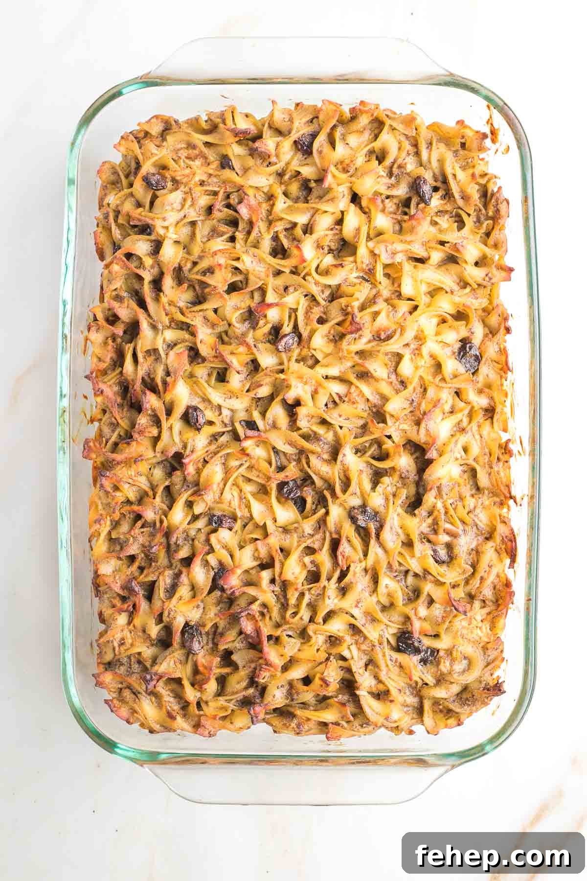 Baked apple raisin noodle kugel in a 9x13 casserole dish.