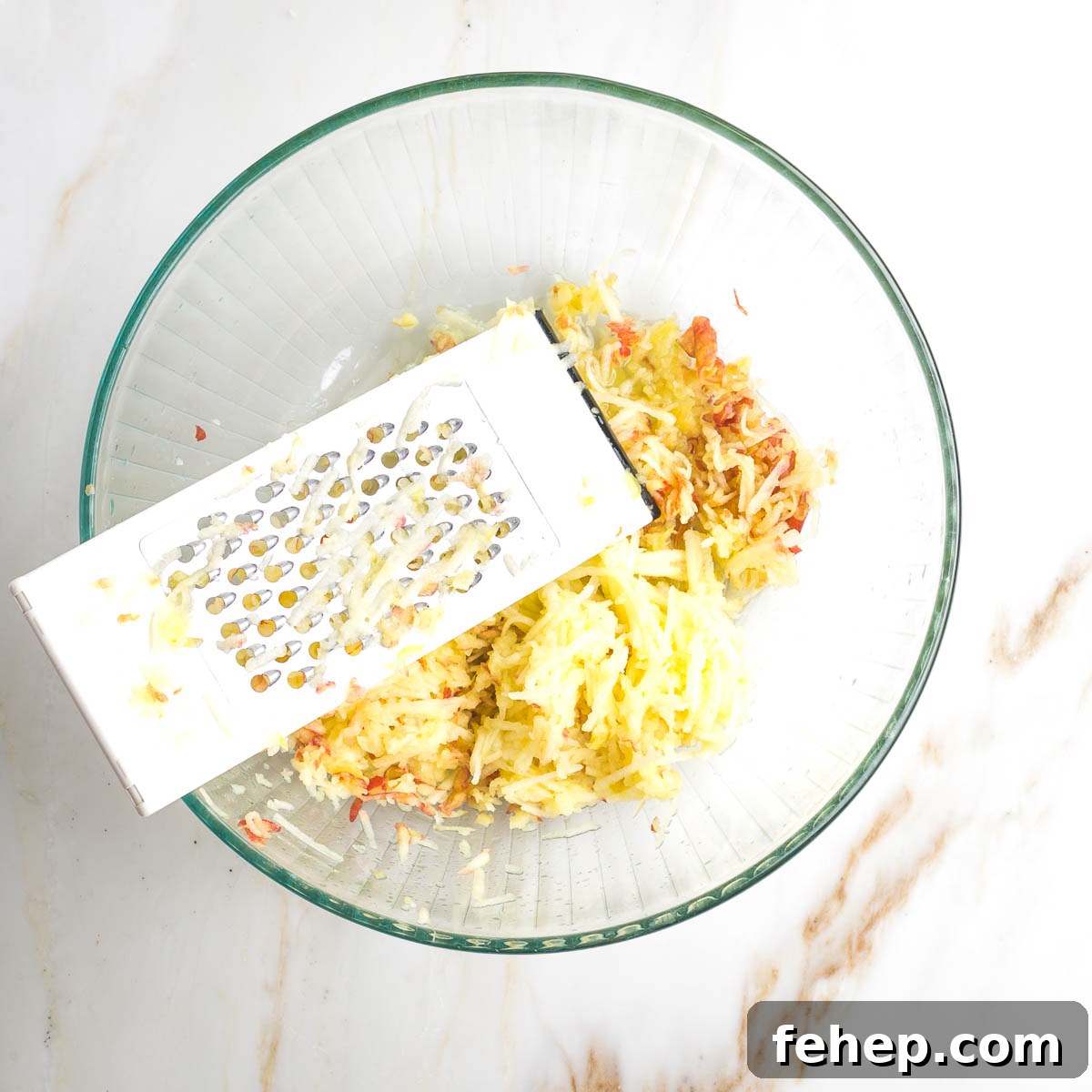 Shredding apples into a large mixing bowl.