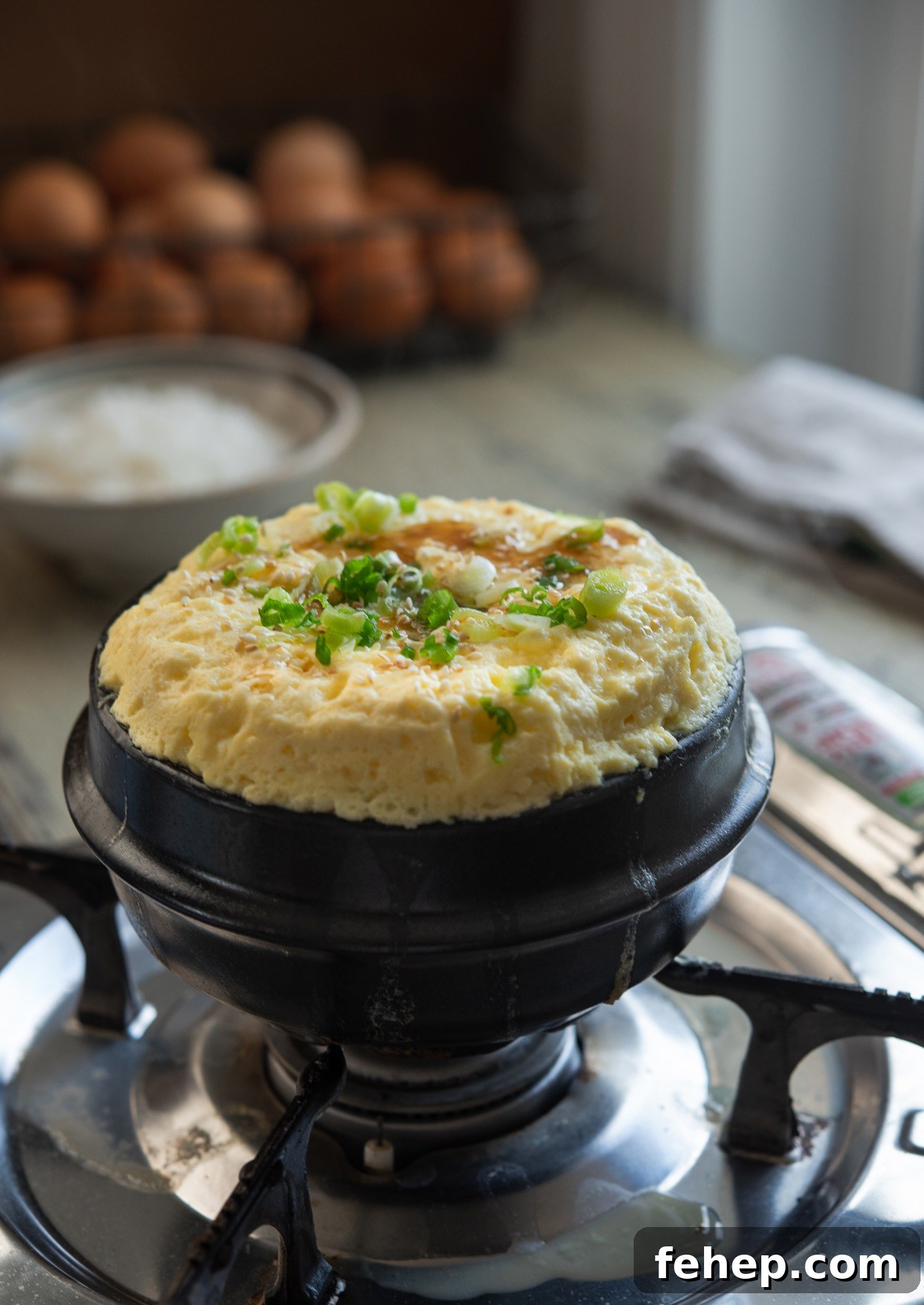 Korean steamed eggs (gyeran jjim) in a ttukbaegi, garnished with chopped green onion.
