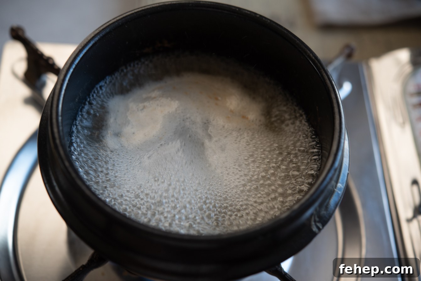 Chicken stock boiling in a ttukbaegi (Korean stone pot) for making gyeran jjim.