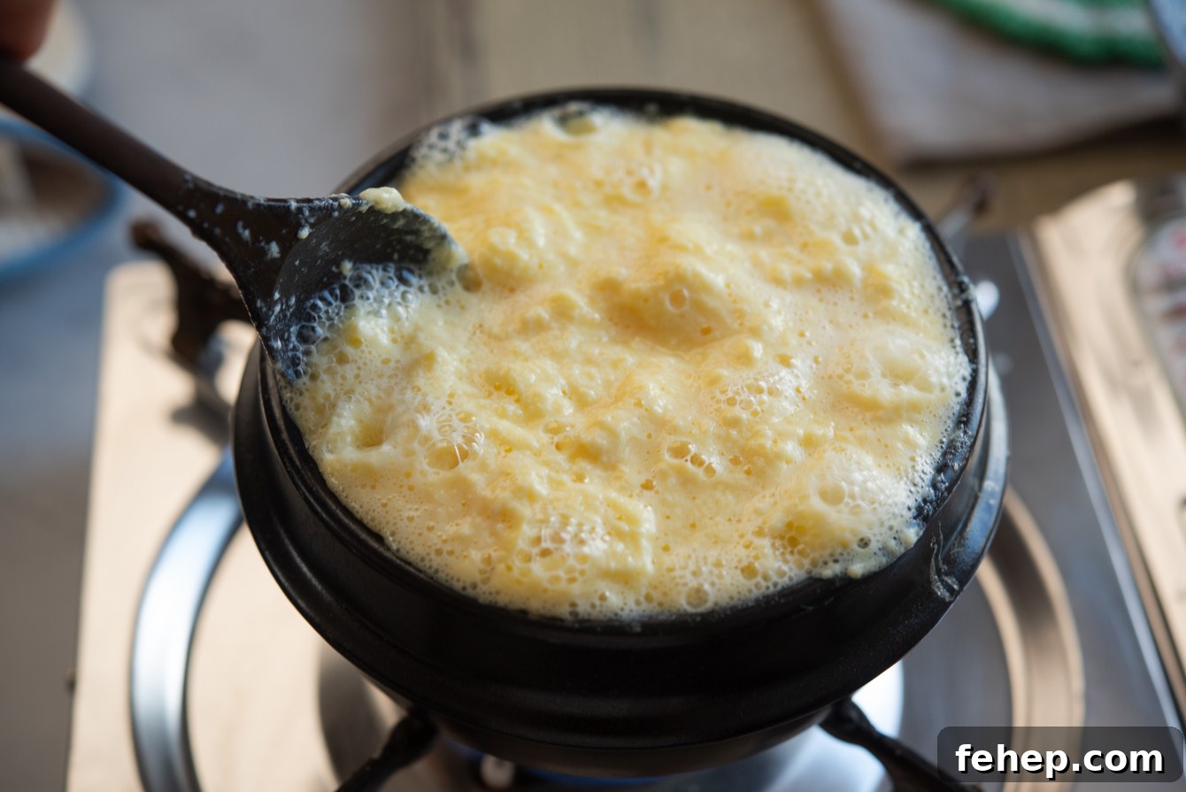 Stirring the egg mixture in a pot while making Korean steamed eggs (gyeran jjim).