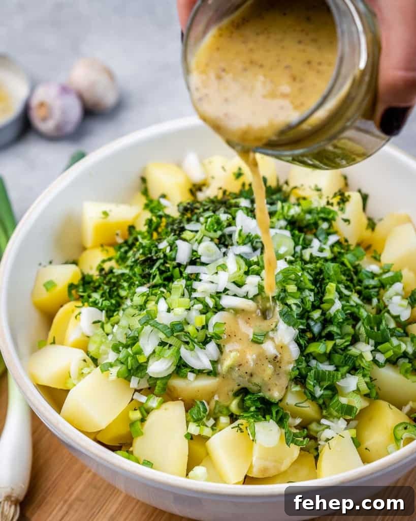 Classic Herbed Potato Salad with Fresh Dill and Chives 7 Pouring dressing over potatoes and chopped herbs.