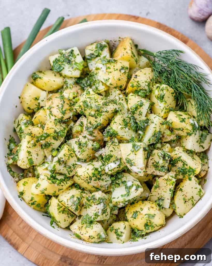 Classic Herbed Potato Salad with Fresh Dill and Chives 10 Potato salad with herbs in a white serving bowl.