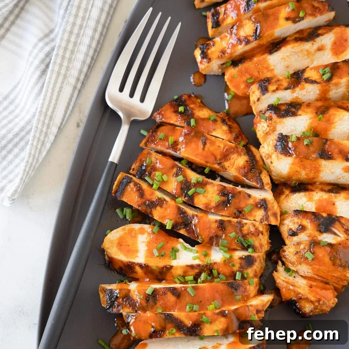 Spicy Buffalo Chicken Salad Recipe with Creamy Ranch Dressing 5 Bright red orange Buffalo grilled chicken breasts on a gray platter with a serving fork.