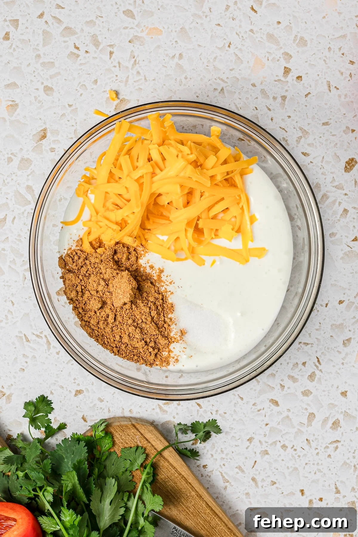 Blended cottage cheese with shredded cheddar and taco seasoning in a microwave-safe bowl.