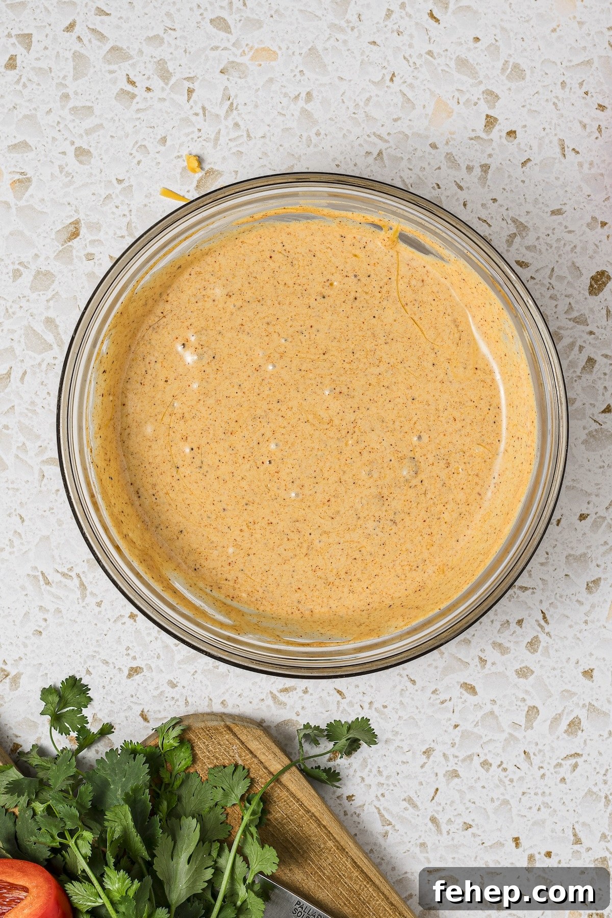 High-protein cottage cheese queso melted and blended in a microwave-safe glass dish.