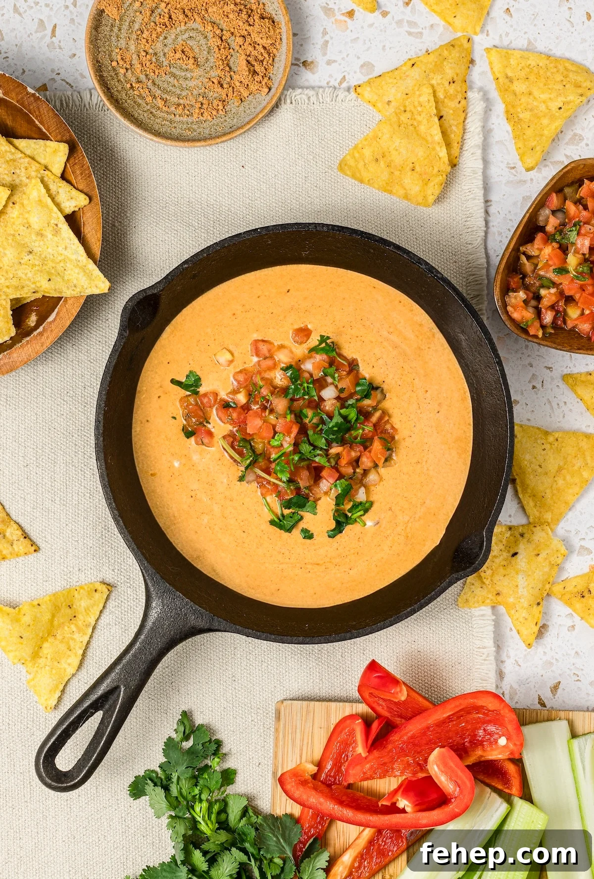 Cottage cheese queso in a small cast iron skillet, topped with pico de gallo and fresh cilantro.