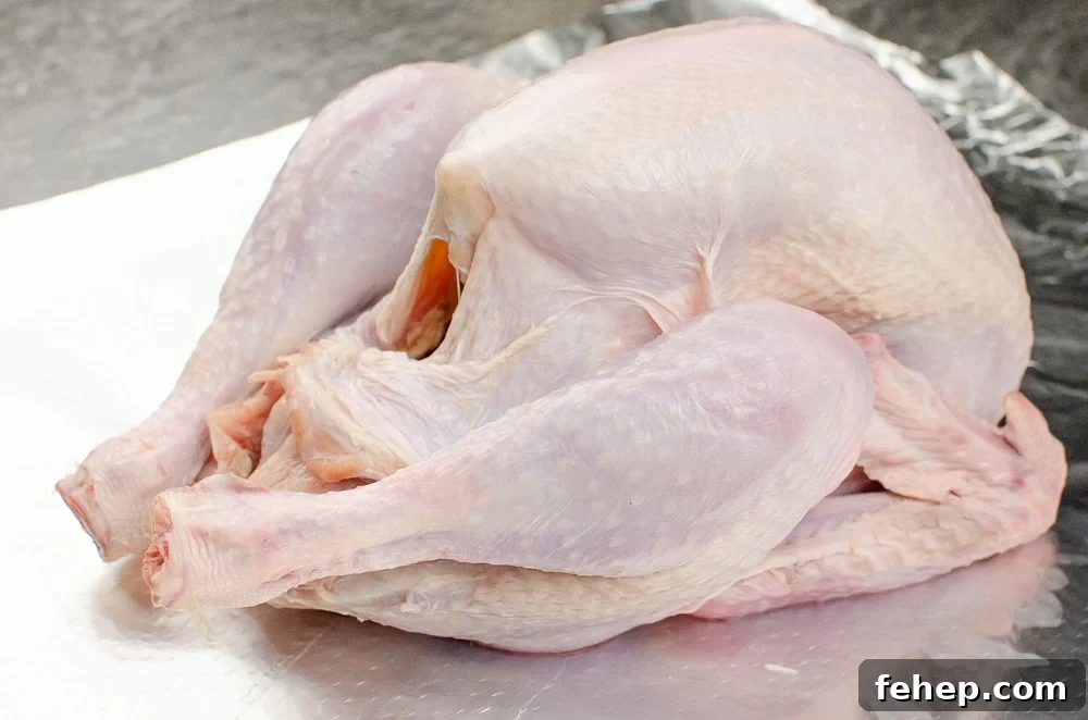 How to Roast a Small Whole Turkey: Step-by-Step Guide 4 A turkey on silver tin foil ready to be prepped for cooking