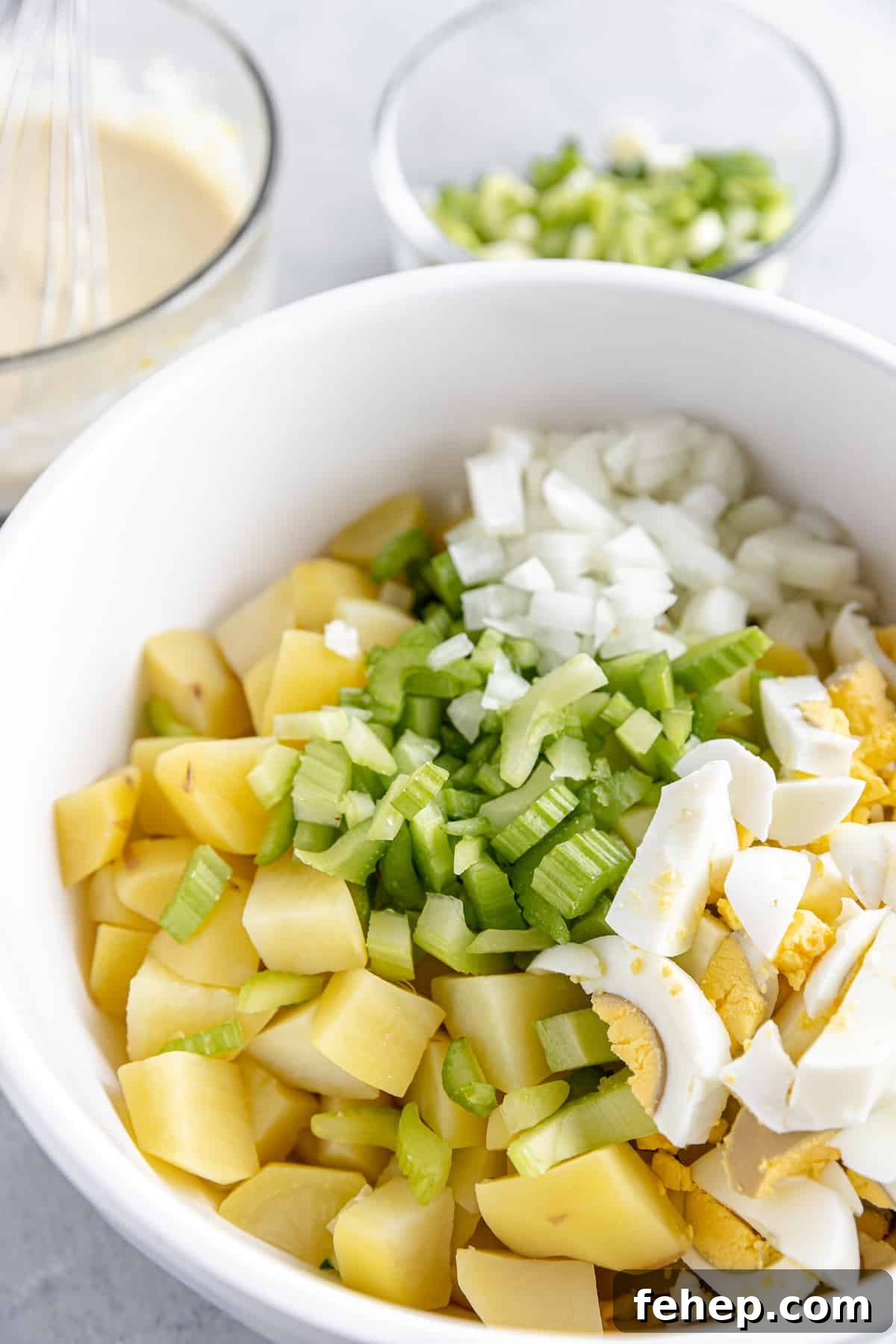 A White Bowl Filled with Uncombined Potato Salad Ingredients