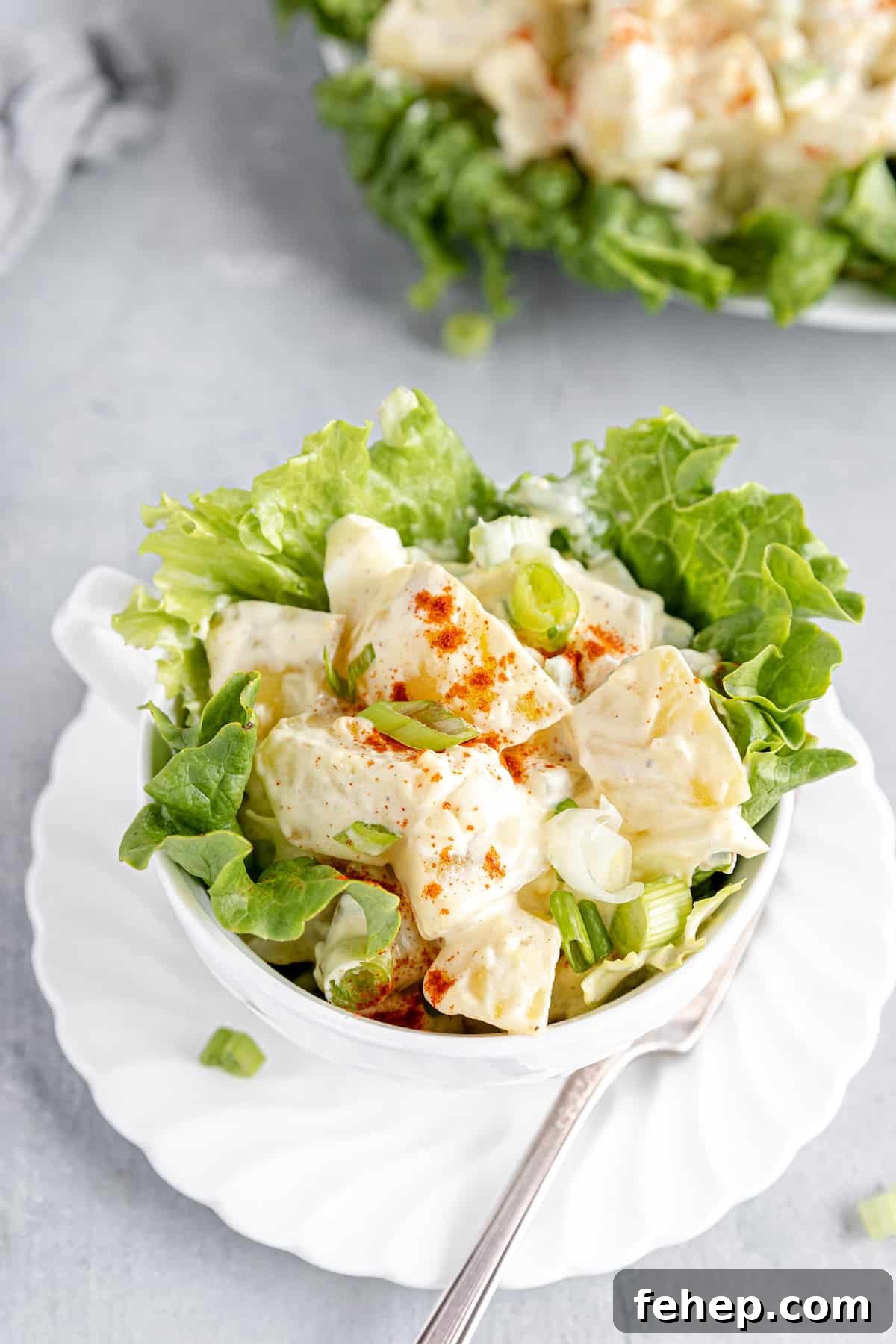 A Close-Up Shot of a Potato Salad in a Large Cup with Lettuce Leaves