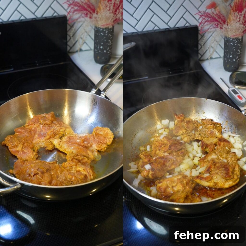 Chicken thighs cooking on a silver pan with onions. 