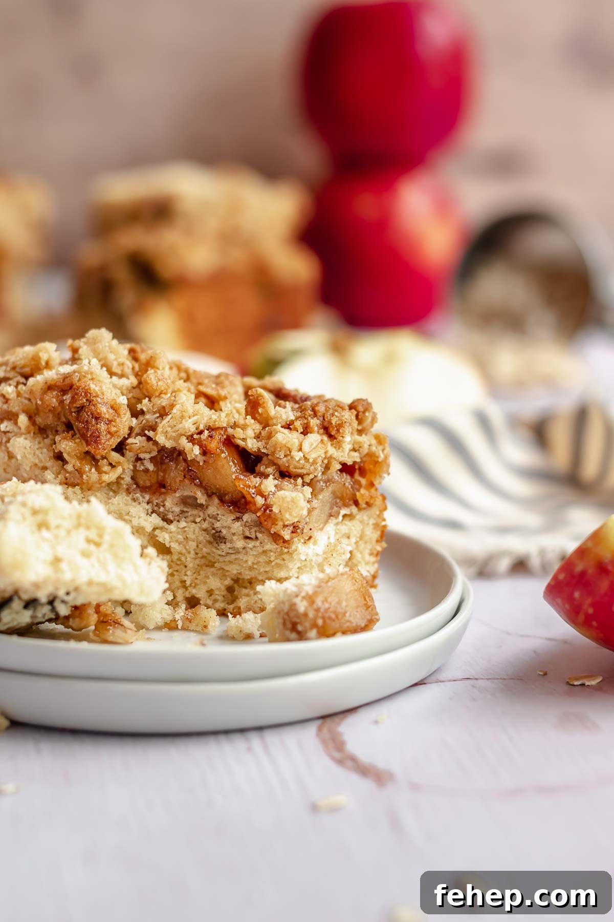 A piece of coffee cake on a place with a fork and piece removed.