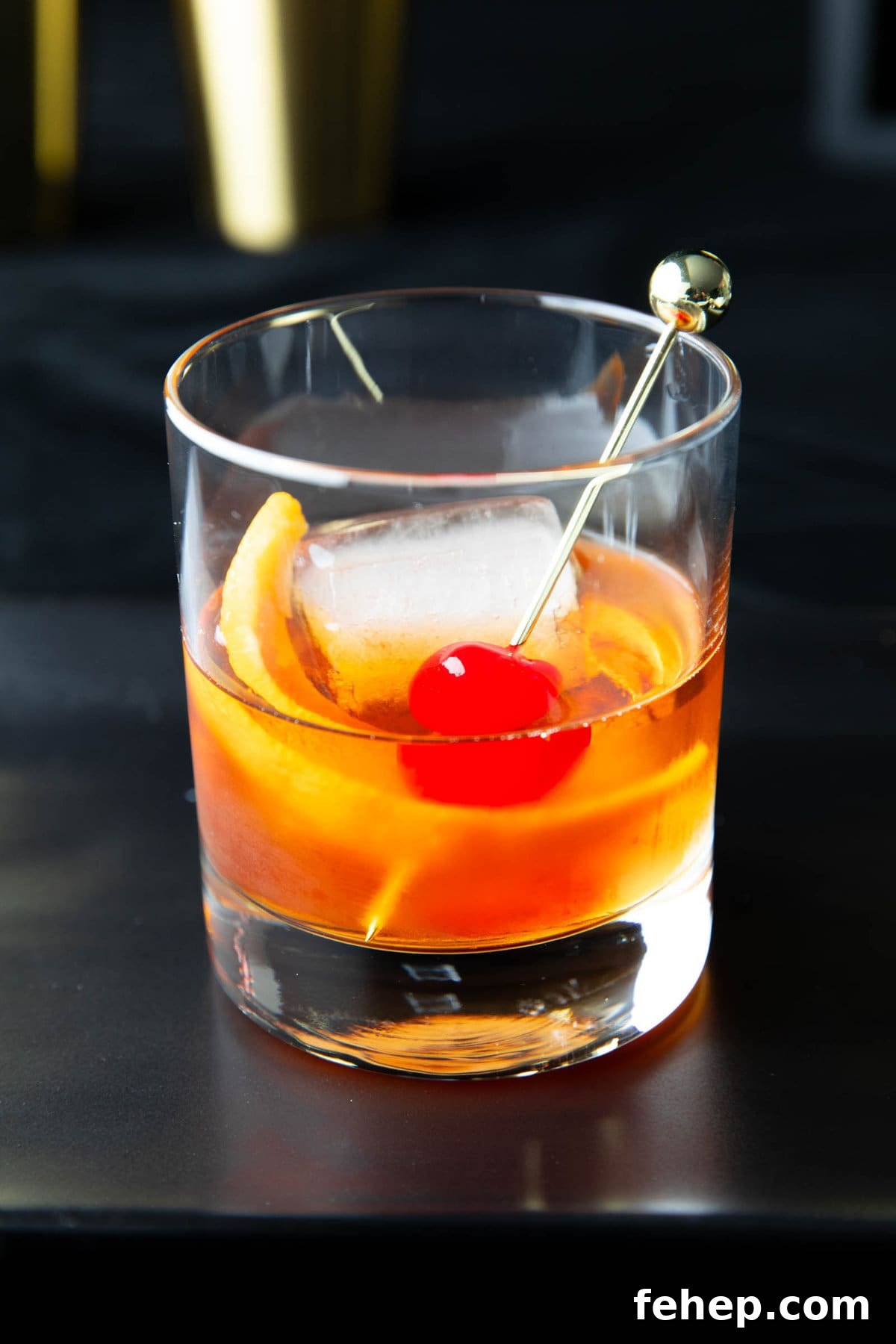 Classic Old Fashioned Cocktail Recipe: How to Make It Perfectly 2 close up of this whiskey cocktail garnished with an orange peel and a maraschino cherry