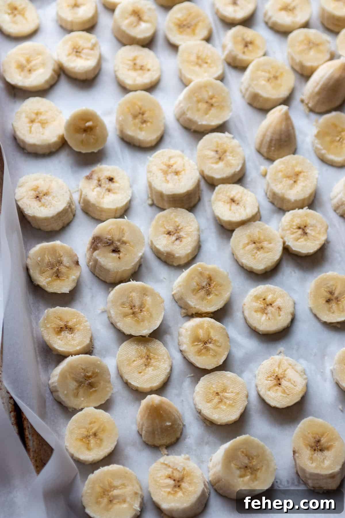 Freeze Bananas for Smoothies: Step-by-Step Guide and Tips 4 A baking sheet with some parchment paper and sliced of bananas.