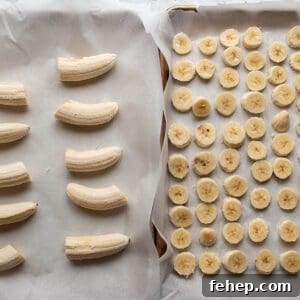 Freeze Bananas for Smoothies: Step-by-Step Guide and Tips 9 Two sheet pans lined with parchment paper, one with sliced bananas and one with halved bananas.