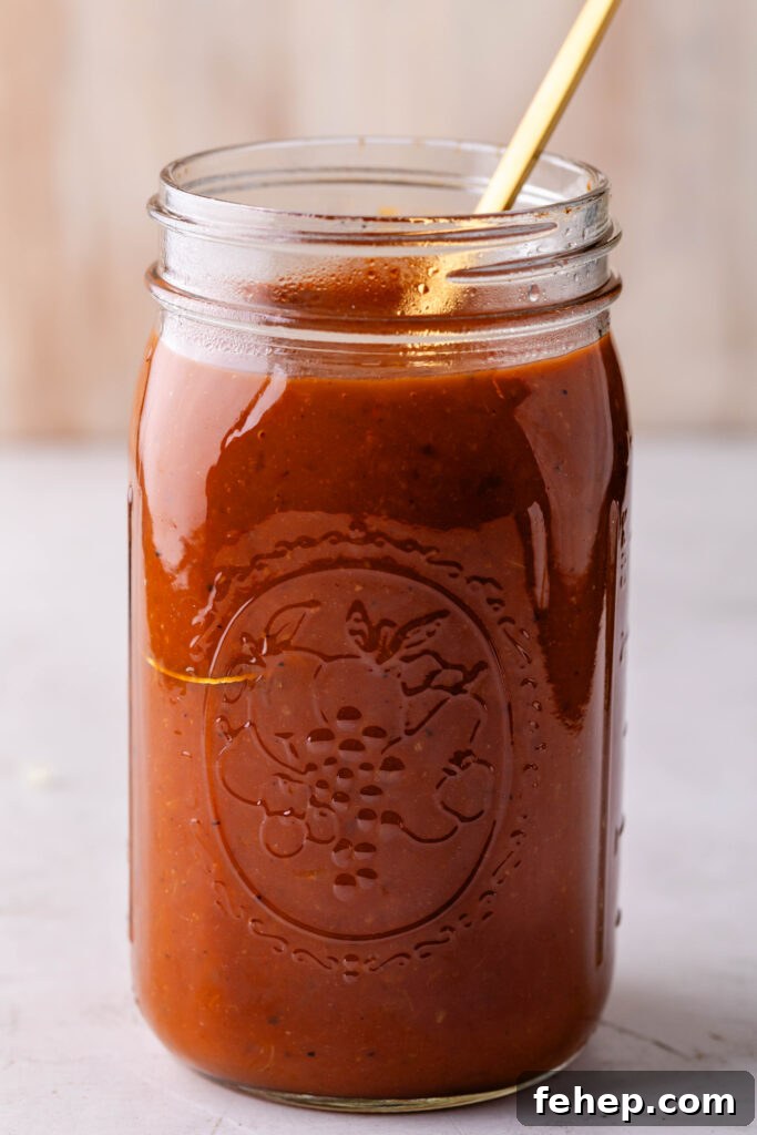 jar of peach bbq sauce with a gold spoon