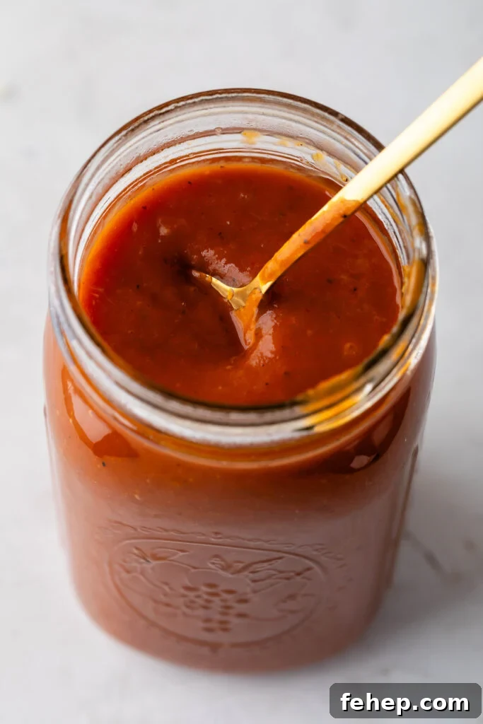 jar of peach bbq sauce with a gold spoon