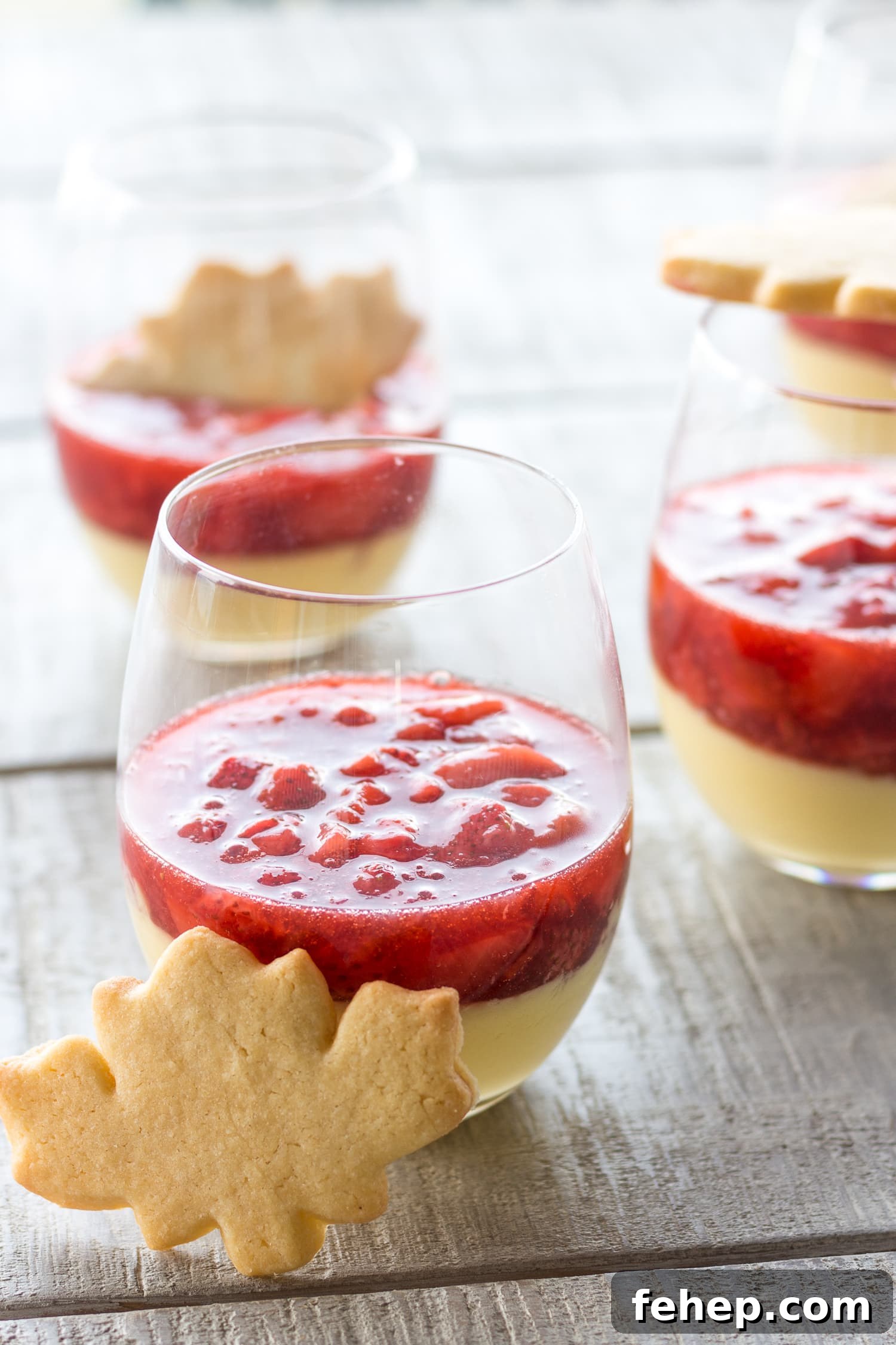 Three glasses of maple custard with strawberry compote with maple leaf shaped sugar cookies