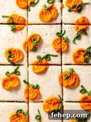 Sliced cake frosted with white frosting and piped mini pumpkins