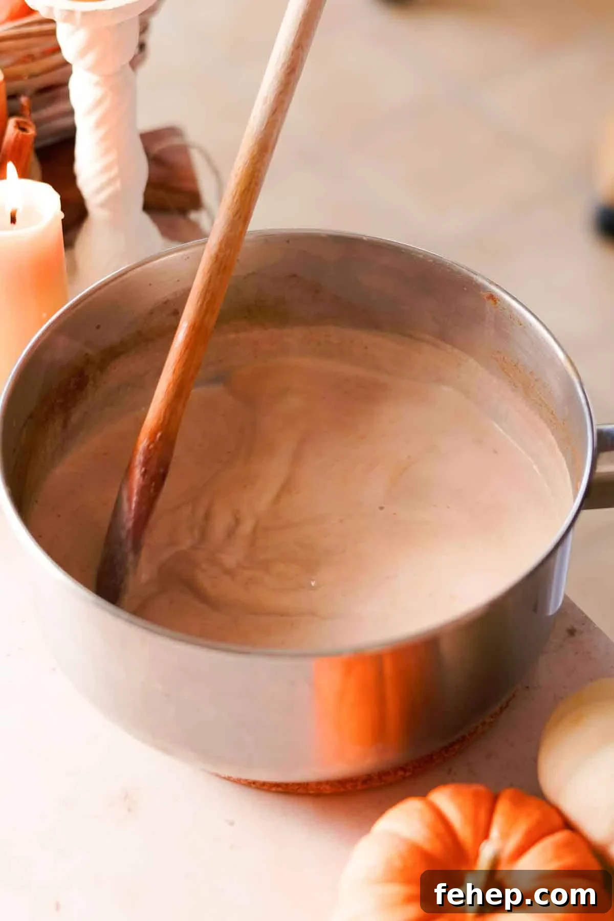 Pumpkin Spice Chai Latte Recipe: Cozy Fall Coffeehouse Drink 5 stirring chai latte in medium saucepan with a wooden spoon