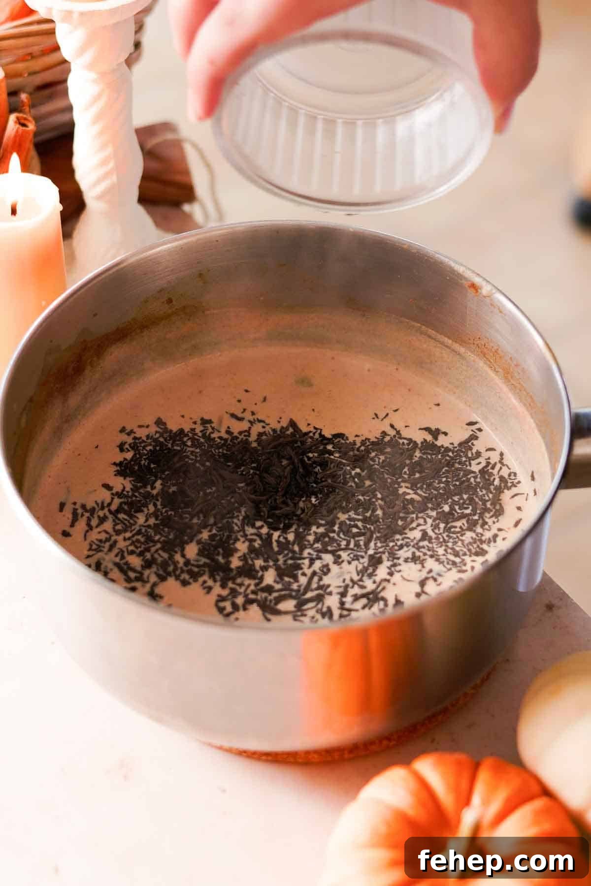 Pumpkin Spice Chai Latte Recipe: Cozy Fall Coffeehouse Drink 6 adding black loose leaf tea leaves to chai in pot