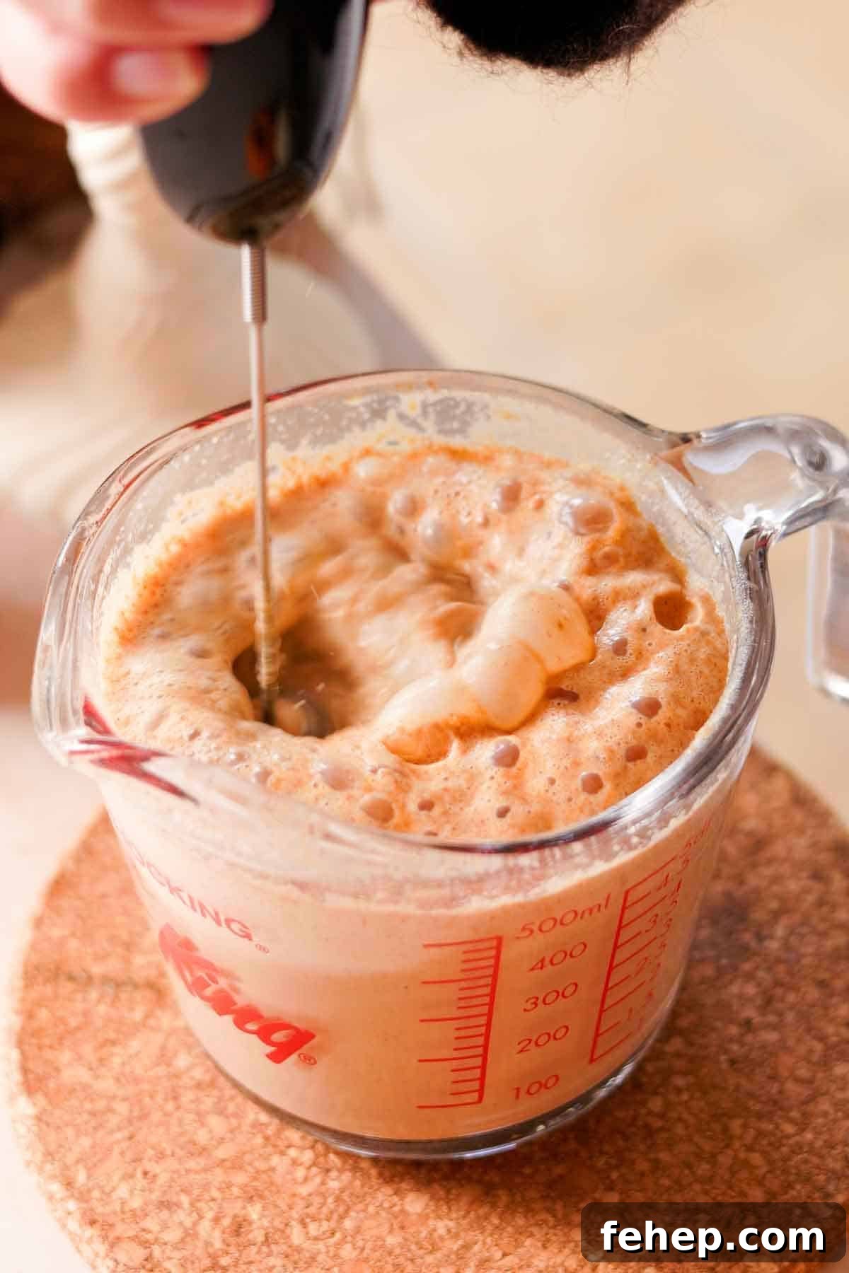 Pumpkin Spice Chai Latte Recipe: Cozy Fall Coffeehouse Drink 8 frothing pumpkin chai latte in glass measuring cup with electric whisk frother