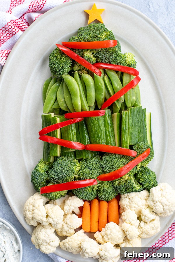Festive Christmas Tree Vegetable Platter Ideas for Holiday Parties 3 Close up of vegetables shaped like a Christmas tree complete with red vegetables as decorations.