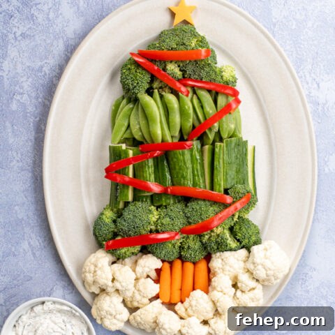 Overhead view of a Christmas Tree Vegetable Tray using tree vegetables to make a tree shape with colorful vegetables as garnishes.