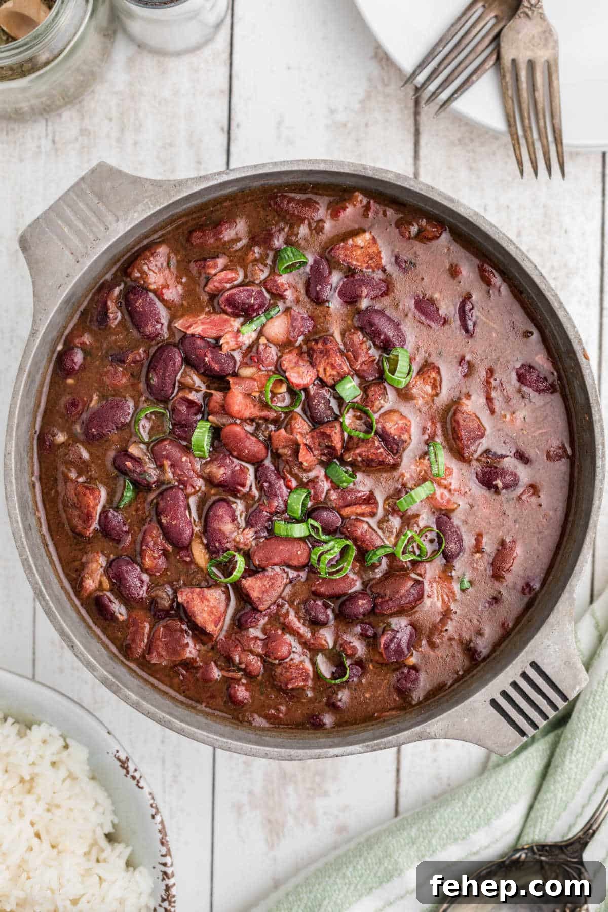 Overhead shot of a pot full of red beans with ham hocks.