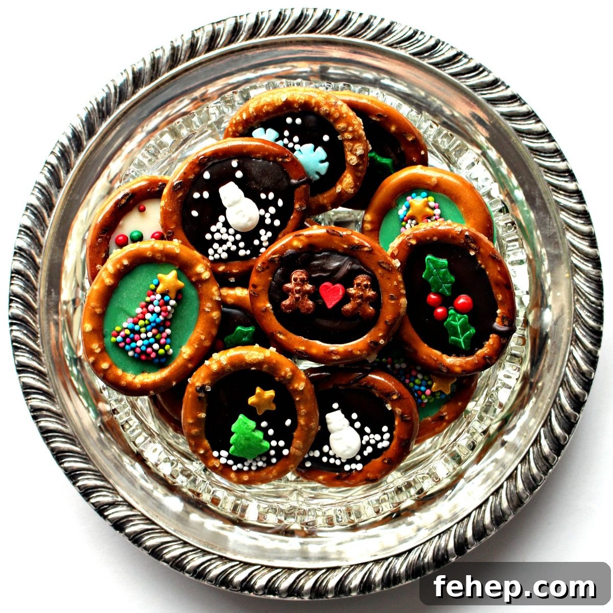 Pretzel rings with chocolate centers and sprinkle designs on a round silver platter.