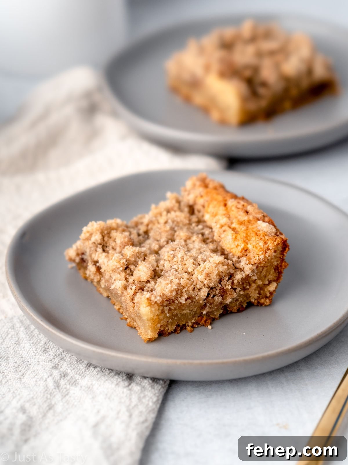 Slice of cinnamon streusel coffee cake on a grey plate.