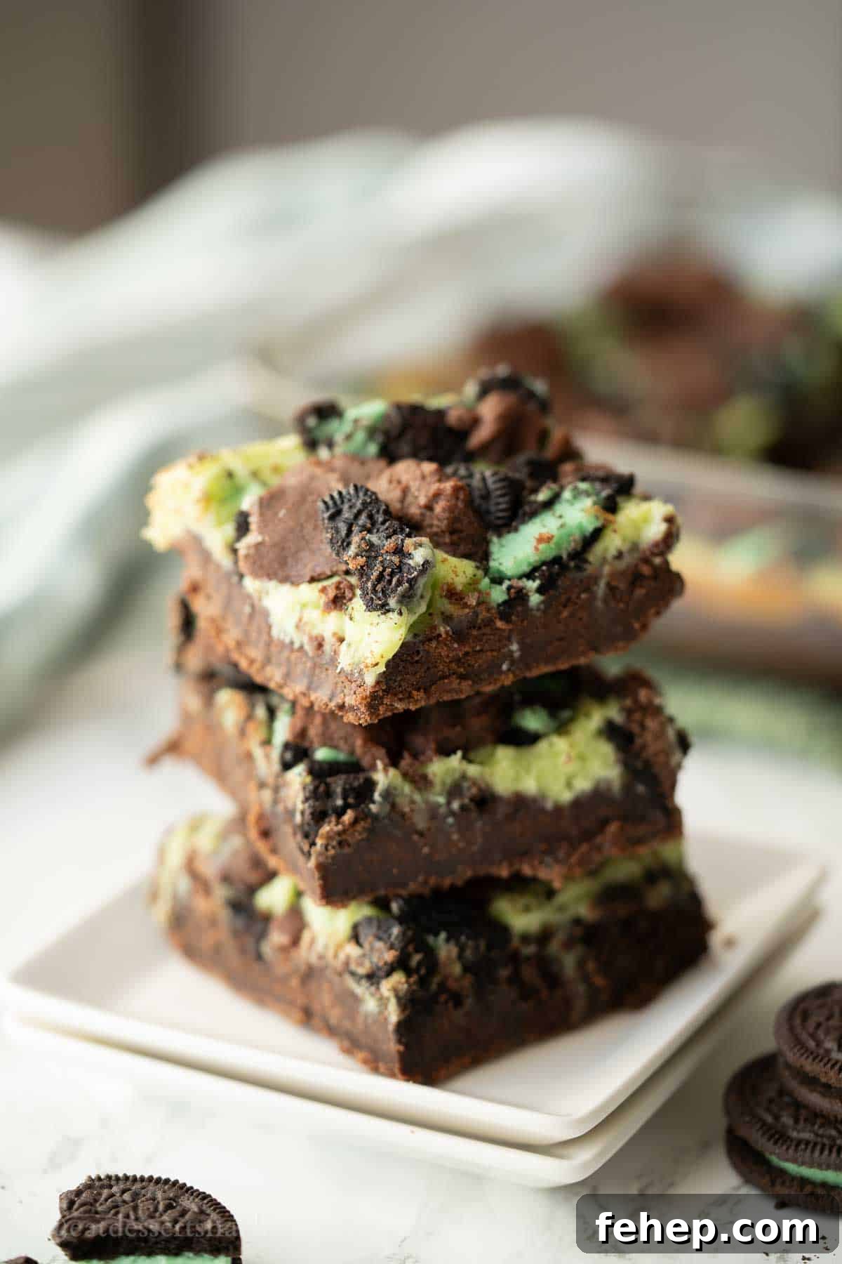 Stack of baked mint cheesecake brownies.