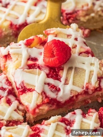 Close up view of slice of raspberry cream bar on gold spatula.