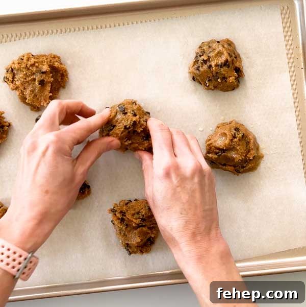 Shaping cookie dough on cookie sheet.