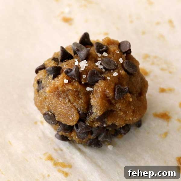 Sprinkling salt on top of cookie.
