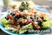 Sweet pork on a blue plate with a flour tortilla and dressing in the background.