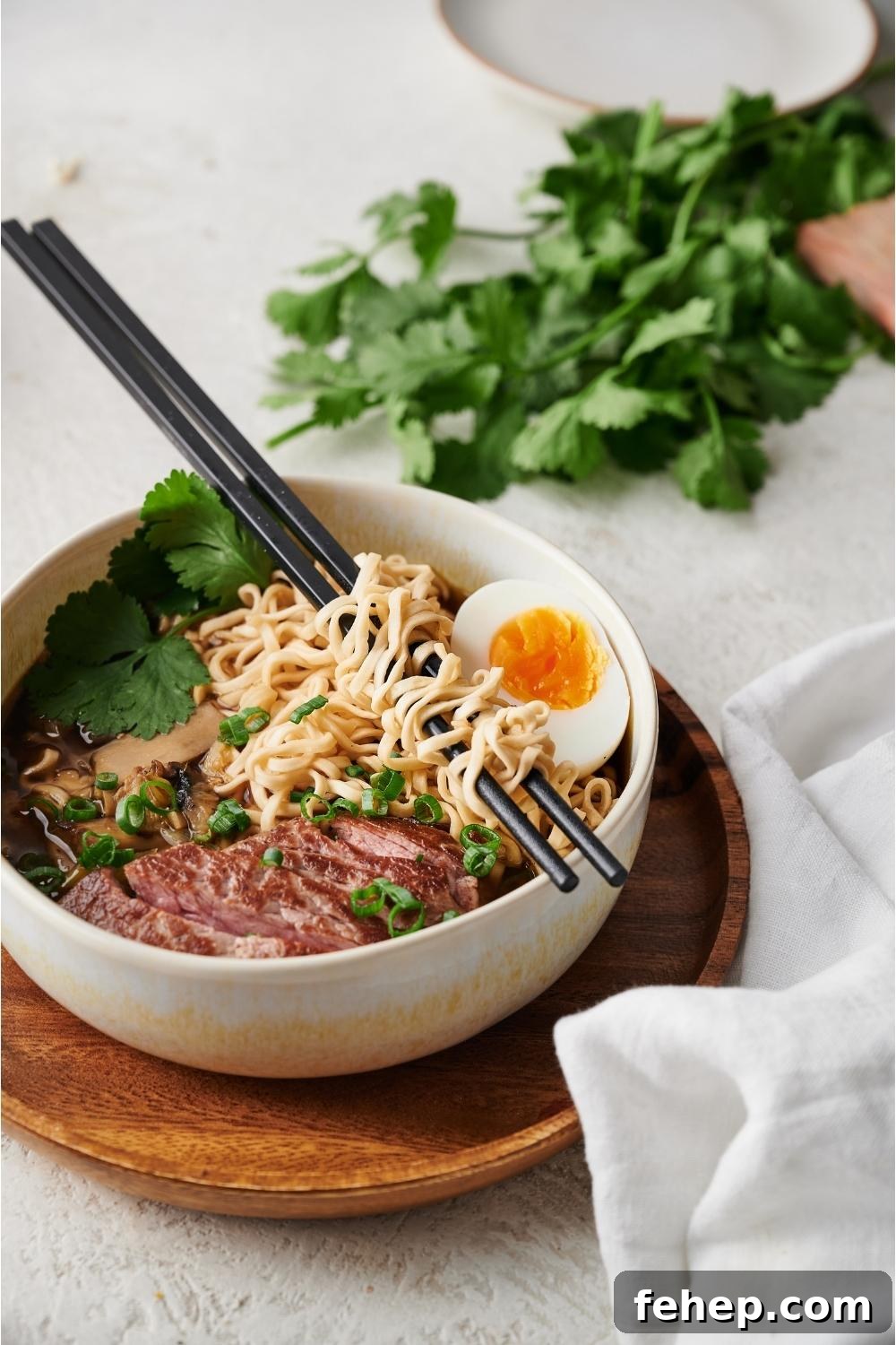 beef ramen in a white bowl on a wood plate with chopsticks resting on the bowl