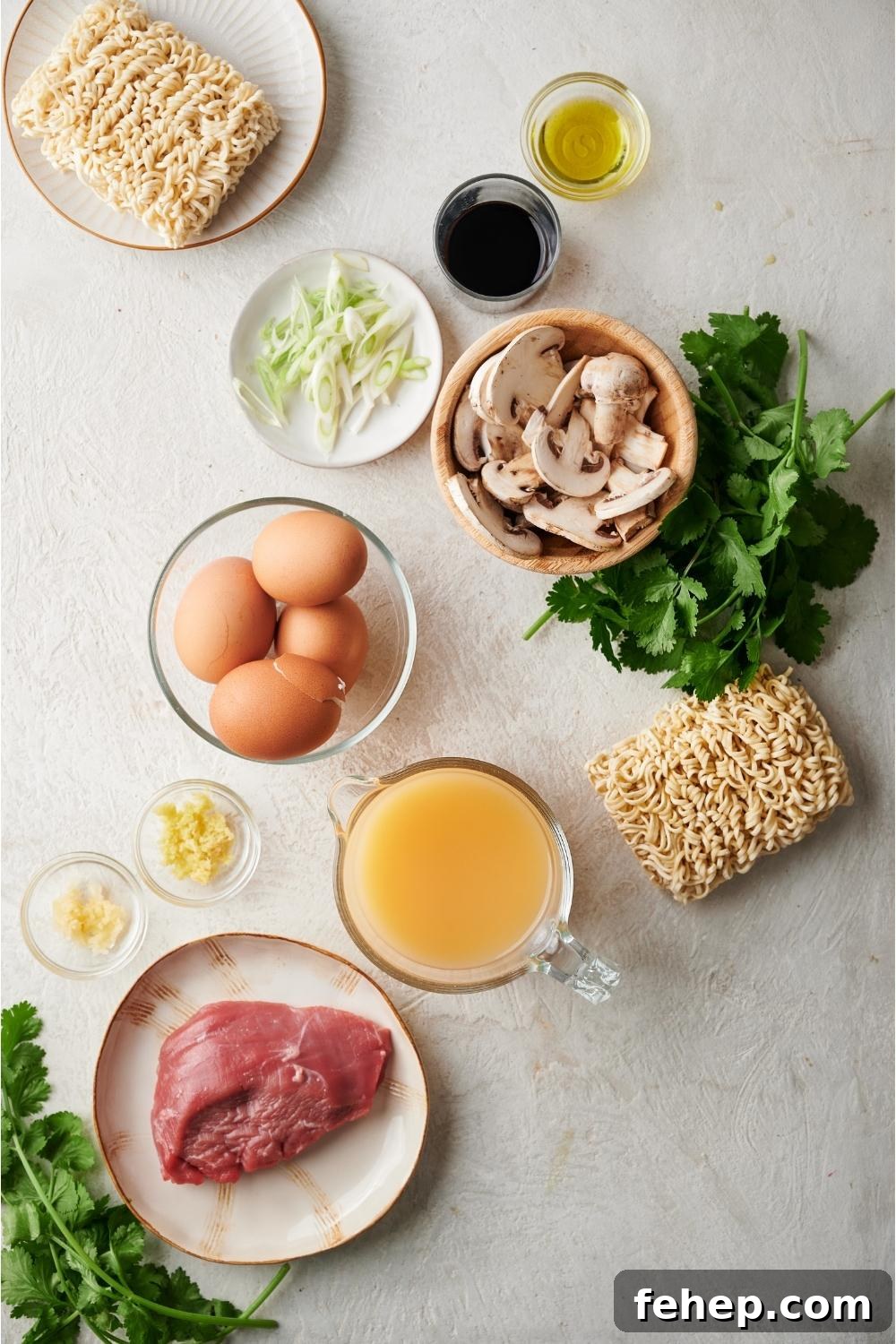 An assortment of ingredients for beef ramen including a plate of raw beef, raw ramen noodles, scallions, eggs, mushrooms, soy sauce, cilantro, and broth