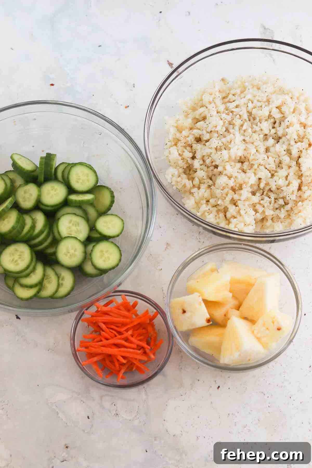 Rice, cauliflower, pineapple and carrots in a small bowl.
