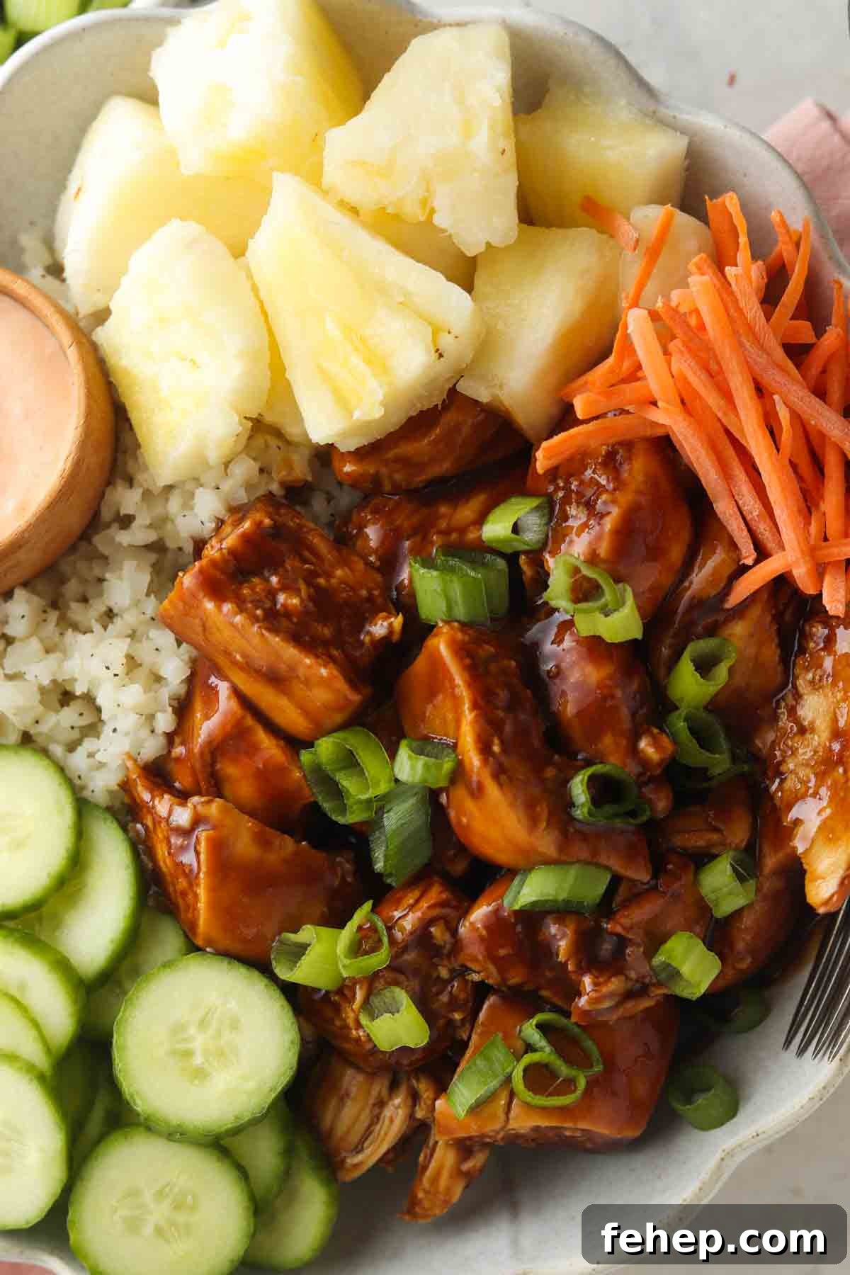 Marinated chicken bowls with cauliflower rice, green onions, carrots, pineapple and cucumbers.